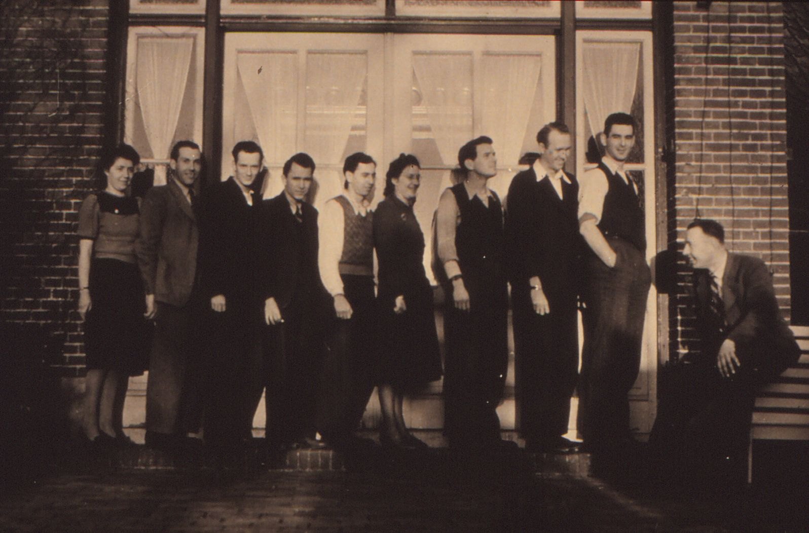 A group of young men and women in front of the house