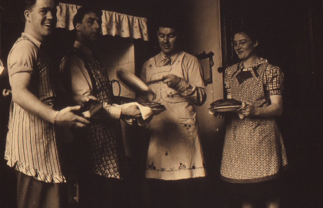 Jonge mannen en vrouwen met schorten en pannen in een keuken