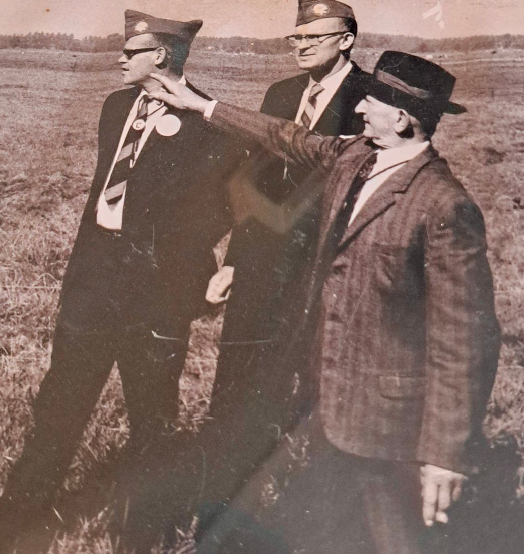 Men in veterans' caps standing in a field
